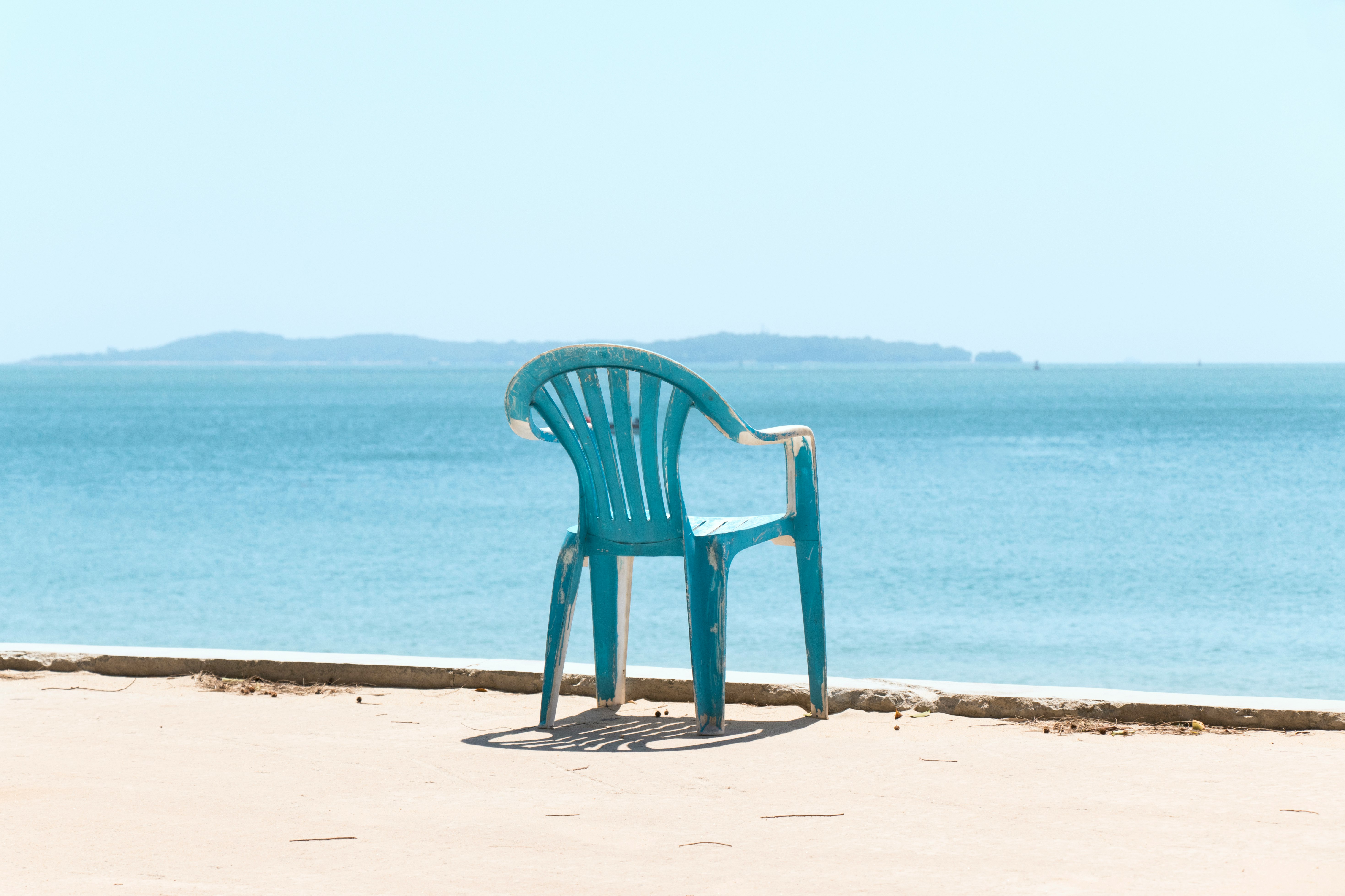 blue monobloc armchair front of sea